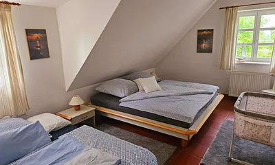 großzügiges Schlafzimmer mit Babyreisebett