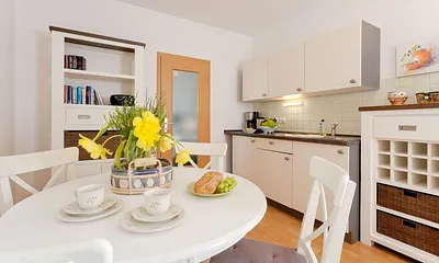 Wohnzimmer mit Esstisch und Küchenzeile