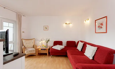 Wohnzimmer mit Esstisch und Küchenzeile