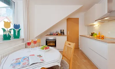 Wohnzimmer mit Esstisch und Küchenzeile