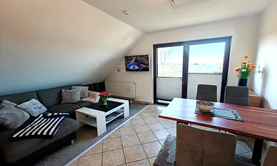 Wohnzimmer mit gemütlicher Couchgarnitur, Esstisch und Küchenzeile