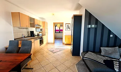 Wohnzimmer mit gemütlicher Couchgarnitur, Esstisch und Küchenzeile