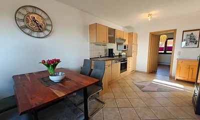 Wohnzimmer mit gemütlicher Couchgarnitur, Esstisch und Küchenzeile