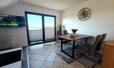 Wohnzimmer mit gemütlicher Couchgarnitur, Esstisch und Küchenzeile