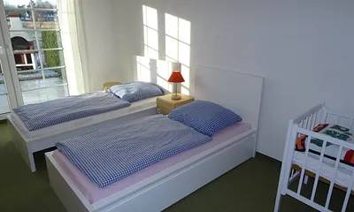 Schlafzimmer 2 mit zwei Einzelbetten und Kindenbett