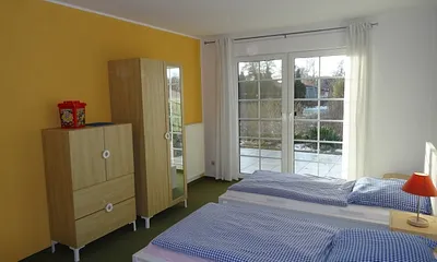 Schlafzimmer 2 mit zwei Einzelbetten und Kindenbett