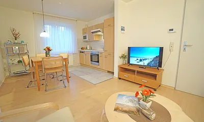 Wohnzimmer mit Esstisch und Küchenzeile