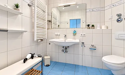 Ein maritim gestaltetes Bad mit Dusche und Fußbodenheizung gehört zum Appartment. 