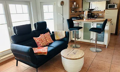 Wohnzimmer mit Funktionscouch und Barhocker