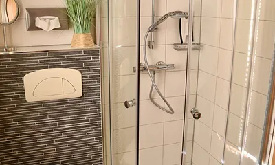 Badezimmer mit Eckrunddusche und Fußbodenheizung