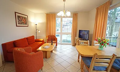 Wohnzimmer mit Schlafcouch, Esstisch und Fernseher