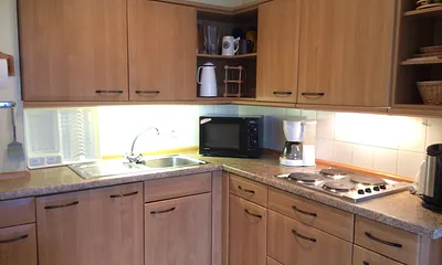 Ceran-Kochfeld (neu), Kühlschrank, Mikrowelle mit Grill, Kaffeemaschine, Thermoskannen, Wasserkocher, Toaster, Flaschenwärmer, reichlich Geschirr und Kochutensilien