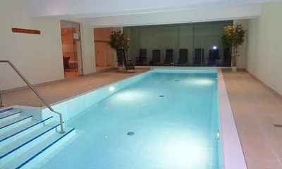 Wellnessbereich mit Schwimmbad und Ruheraum im Hintergrund