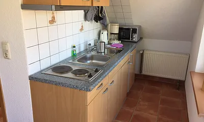 ....und helle Küchenzeile mit Herd,Abluft und Kühlschrank