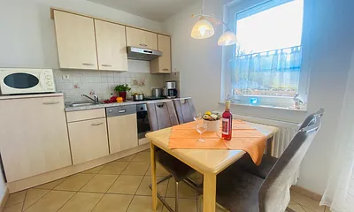 Essecke mit komplett ausgestatteter Küchenzeile (z.B. Backofen, Geschirrspüler, Mikrowelle, Kühlschrank mit Gefrierfach, Geschirr usw.)