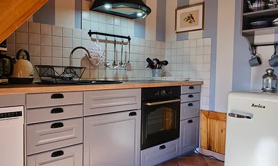 Komplett ausgestattete Küche mit Herd, Backofen, Kühlschrank und Kleingeräten