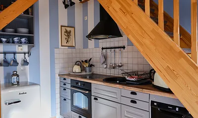 Komplett ausgestattete Küche mit Herd, Backofen, Kühlschrank und Kleingeräten