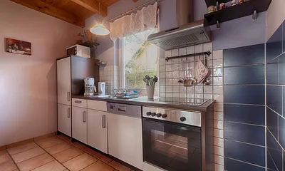 Komplett ausgestattete Küche mit Herd, Backofen, Kühlschrank und Kleingeräten