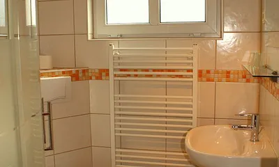 Modernes Badezimmer mit Dusche, ein Handtuchset pro Person