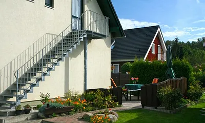 Sie sehen den Eingang zur Ferienwohnung, ihren Parkplatz, ihre Terrasse und den Fahrradunterstellraum.