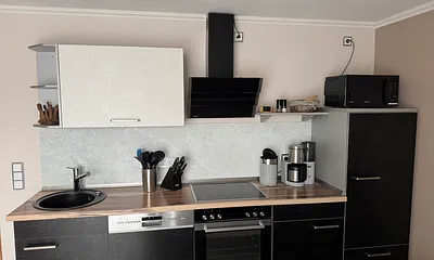 Die hochwertige Küche ist ausgestattet mit E- Herd, Geschirrspüler, Mikrowelle, Kühlschrank, Kaffeemaschine, Wasserkocher, Toaster, Eierkocher und Radio. 