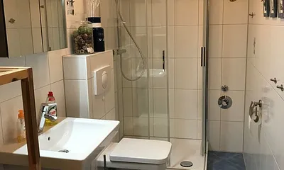 Im raumhoch gefliesten Bad befinden sich das WC, die grosse Dusche und der Waschtisch. Ein Fön befindet sich im Badschrank. 