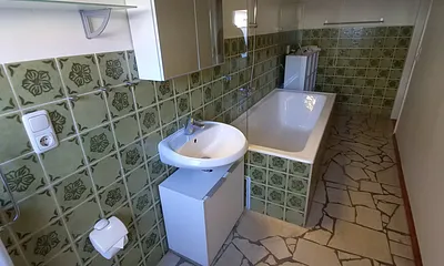 Bad mit Wanne und Duschrollo