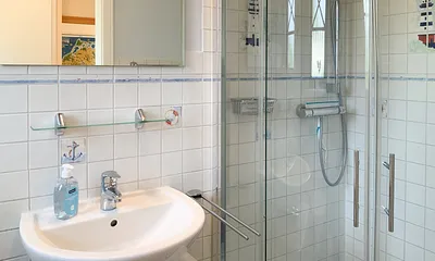 Im Badezimmer EG befindet sich eine große Dusche, Waschbecken und WC
