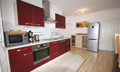 Küchenzeile mit Backofen und großem Kühlschrank mit Tiefkühlunterteil