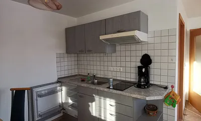 Küchenzeile mit Ceranfeld und Kühlschrank ohne Gefrierfach