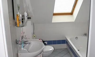 Wannenbad, hinter der Tür eine Waschmaschine, Zugang vom Flur