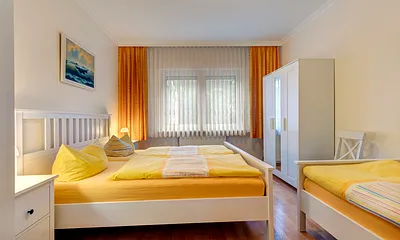 Schlafzimmer mit Doppel- und Einzelbett, 2 Kleiderschränke, Rolläden vor dem Fenster