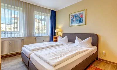 Schlafzimmer mit Boxspingbett und Flat-TV