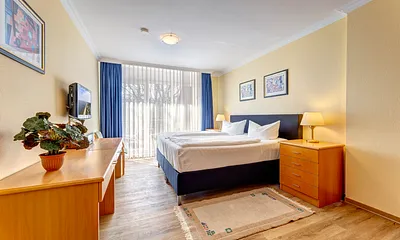 Schlafzimmer I mit Doppelbett, Kleiderschrank und Flat-TV und Zugang zur Dachterrasse