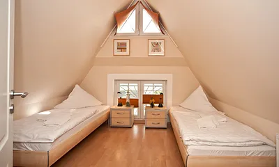 Gemütliches Schlafzimmer im Spitzboden mit Fernseher, besonders beliebt bei den Kindern.reisebett