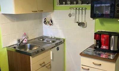 Jetzt befinden wir uns in der Küche. Zusehen ist die Sitzecke sowie die Spüle und die Kochstelle. Die Tür gerade zu geht ins Bad und die Tür rechte Seite führt in den Wohn/Schlafbereich.