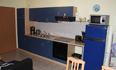 Küchenzeile mit Herd, Kühlschrank, Kaffeemaschine, Wasserkocher, Toaster.