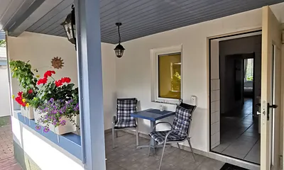 Von der überdachten Terrasse gelangt in die Küche mit Essbereich