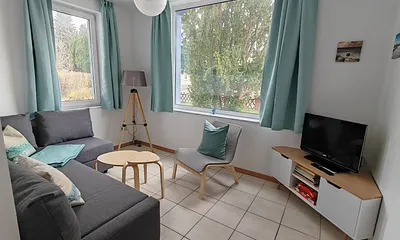 Die Couch lässt sich mit einfachen Handgriffen in eine Schlafgelegenheit oder Lümmlecke verwandeln. Neben dem Fernseher gibt es eine Auswahl an Büchern für Groß und Klein und Spielesammlung