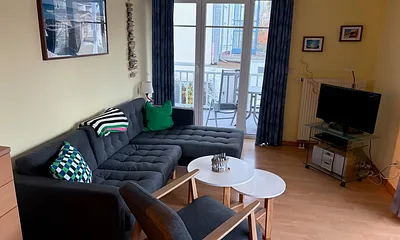 Wohnzimmer mit Schlafsofa und Zugang zum Balkon II
