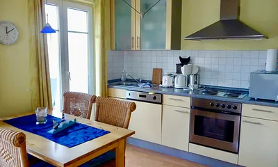 Küchenzeile mit Esstisch und Zugang zum Balkon