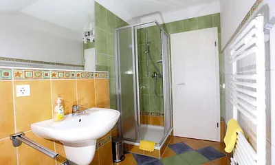 Blick in das farbenfrohe Bad mit Dusche