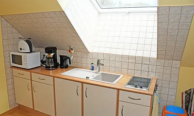 Separate Küche mit Schlafcouch für 1 Person, Ceranfeld (2 Felder), Kühlschrank mit Gefrierfach, Mikrowelle, Kaffeemaschine, Wasserkocher, Toaster und diversen Küchenutensilien.