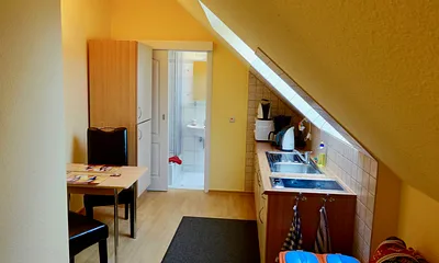 Separate Küche mit Schlafcouch für 1 Person, Ceranfeld (2 Felder), Kühlschrank mit Gefrierfach, Mikrowelle, Kaffeemaschine, Wasserkocher, Toaster und diversen Küchenutensilien.