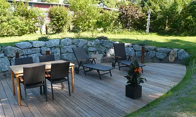 große Terrasse mit Bestuhlung und Liegen im äußeren Gartenbereich