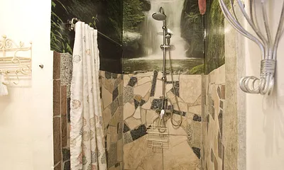 In Marmor gefasster, ebenerdiger Duschbereich mit Regenschauerdusche