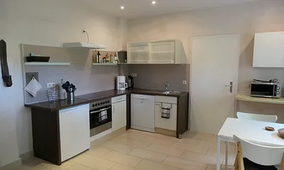 Küchenzeile ausgestattet mit Backofen, 4-Platten-Cerankochfeld, Kühlschrank mit Gefrierfach, Geschirrspülmaschine, Mikrowelle, Kaffemaschine, Wasserkocher und Toaster