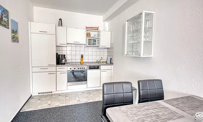 Fewo Mehlschwalbe: Der Blick in die Küche, komplett ausgestattete Einbauküche mit Backofen und großem Esstisch.