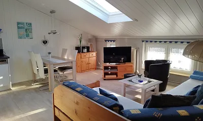 Wohnzimmer oder Wohnschlafraum mit integrierter Küche. 2016 weiße Vertäfelung und Plankenboden, neue Küche.