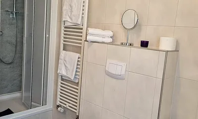 Das Badezimmer mit Badewanne und Dusche